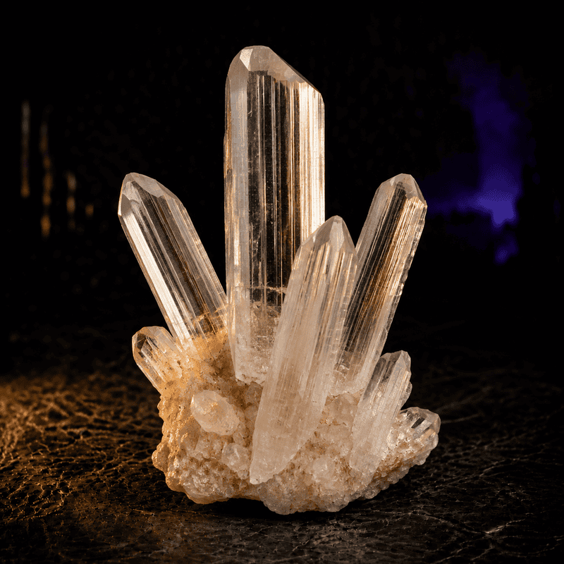 Close-up of a clear quartz crystal cluster on dark background.