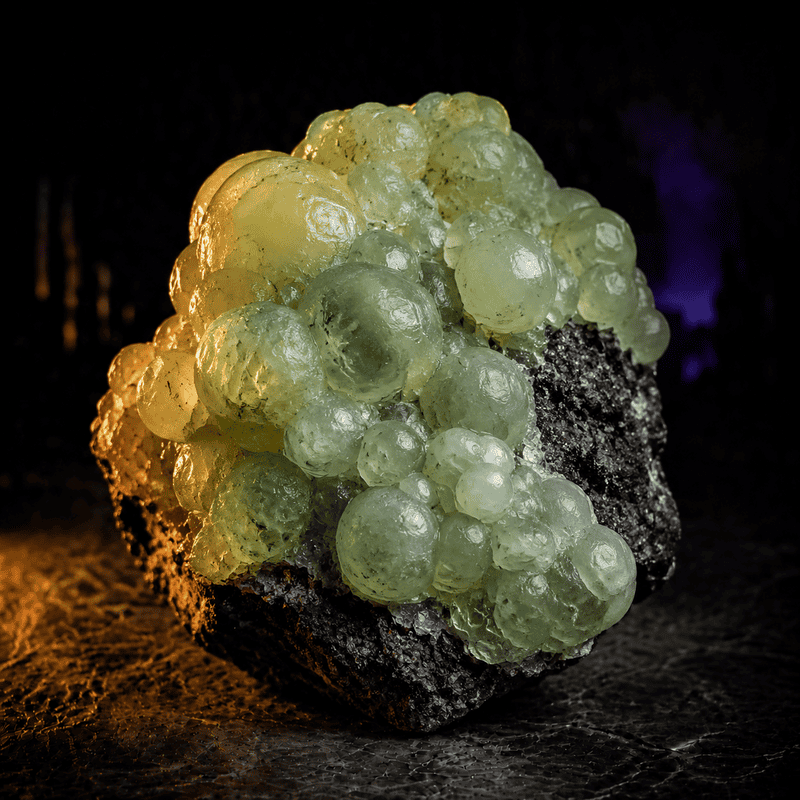 Close-up of a green mineral with bubble-like formations on a dark surface.