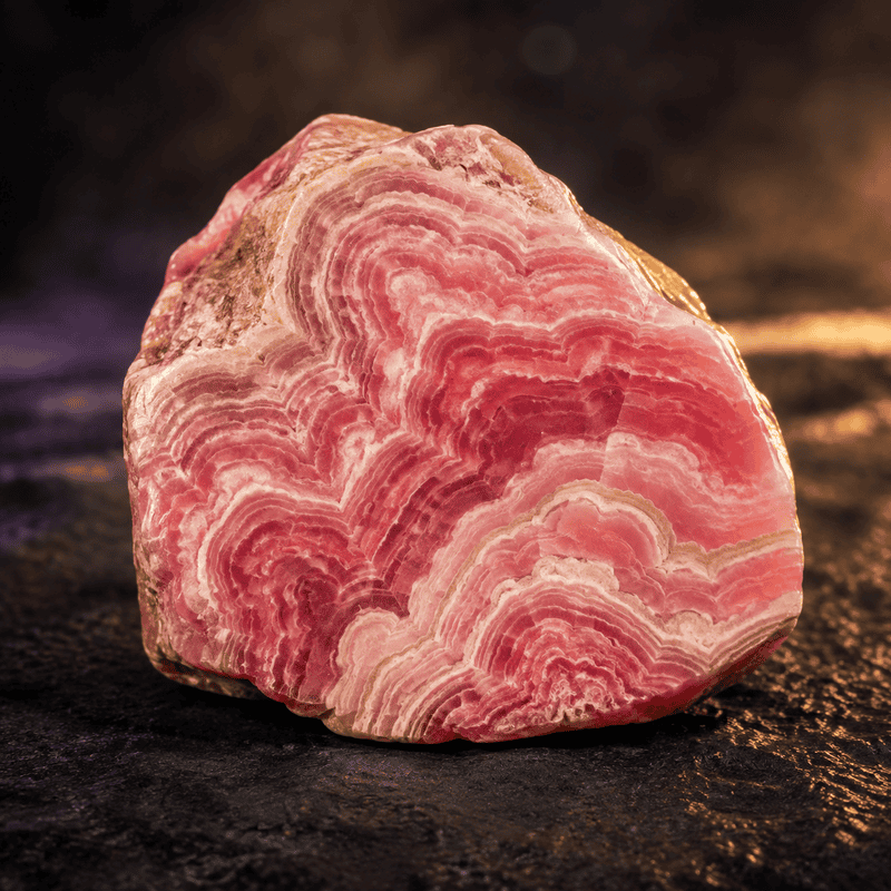 Close-up of pink rhodochrosite mineral with intricate banding patterns.